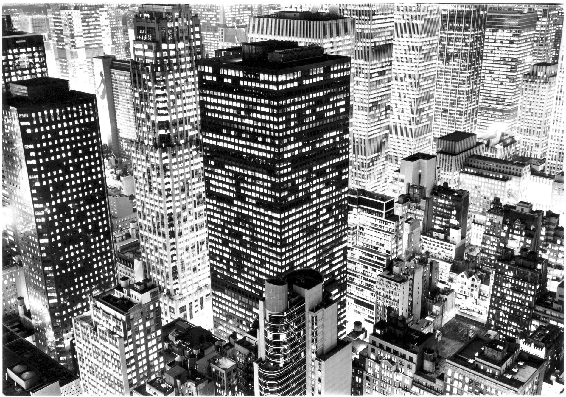 Fotografía de edificios neoyorquinos de noche con ventanas iluminadas