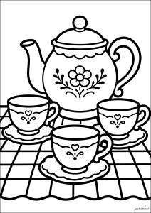Tetera y tazas sobre un mantel
